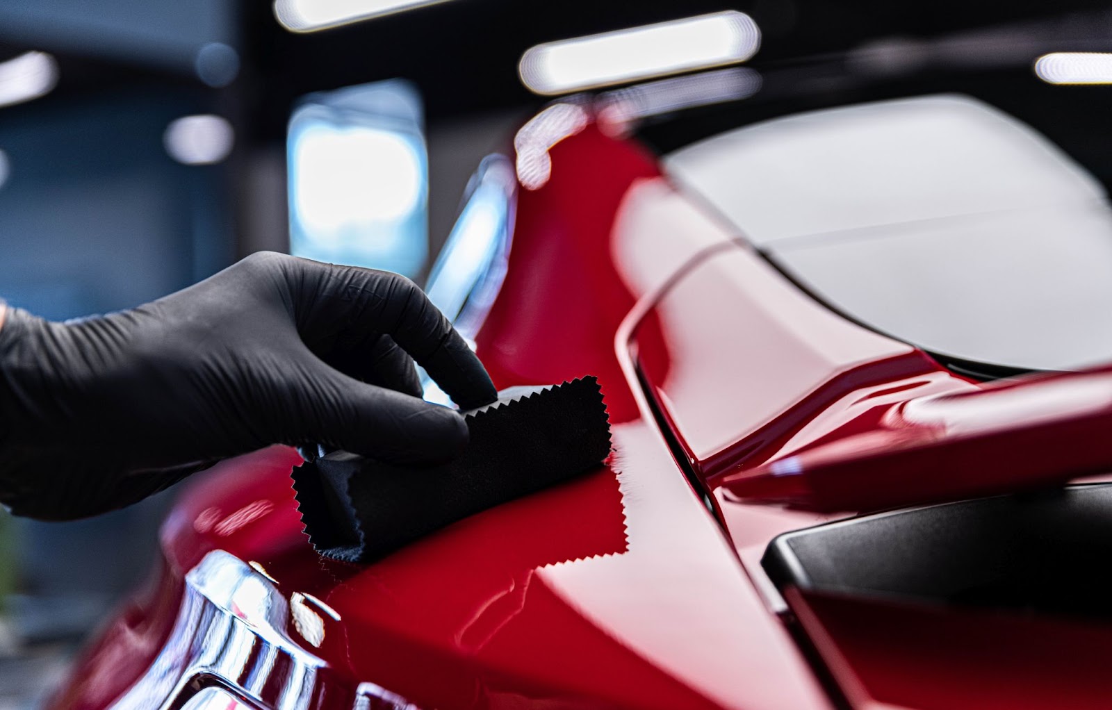 System X ceramic coating being wiped down on a red sports car